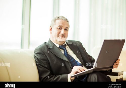 experienced-businessman-working-on-laptop-sitting-on-sofa-in-a-private-office-MPCXTW experienced-businessman-working-on-laptop-sitting-on-sofa-in-a-private-office-MPCXTW